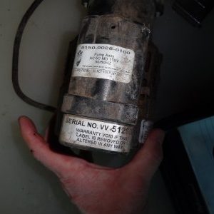 A hand holding an old device with the label " no. Vi-6 1 9 ".