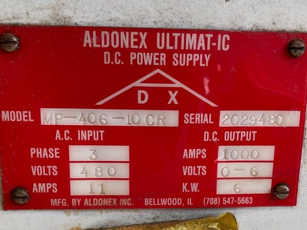 A red sign with the words " aldonex ultimat-ic dc power supply dx " on it.