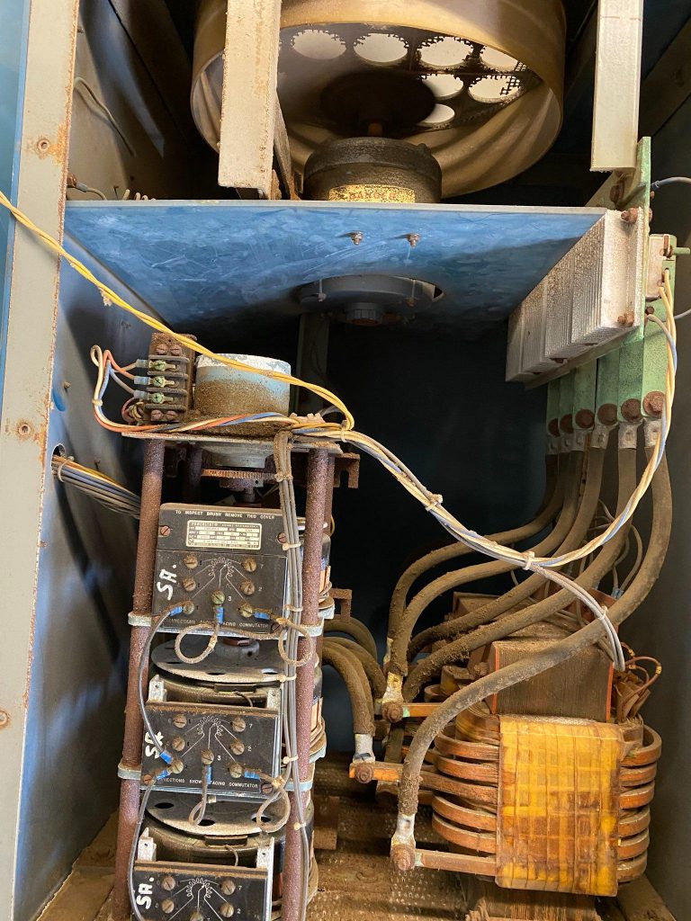 A view of an electrical box with wires and switches.