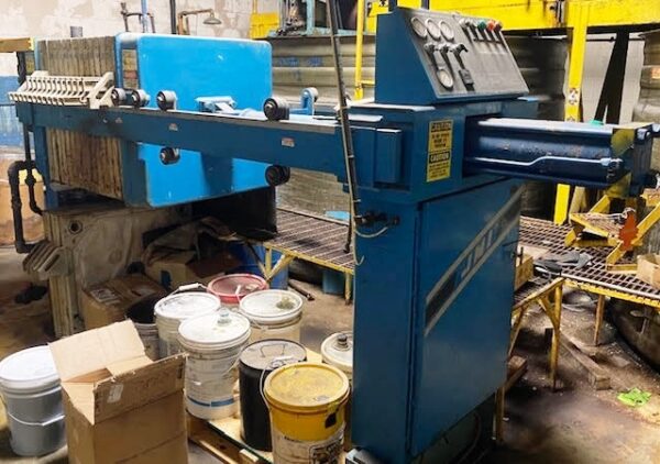 JWI 10 cu. ft. Filter Press machine with some paint buckets below