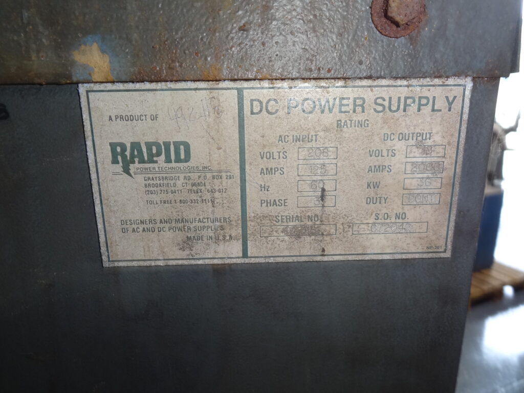 Rusty DC power supply label on metal enclosure