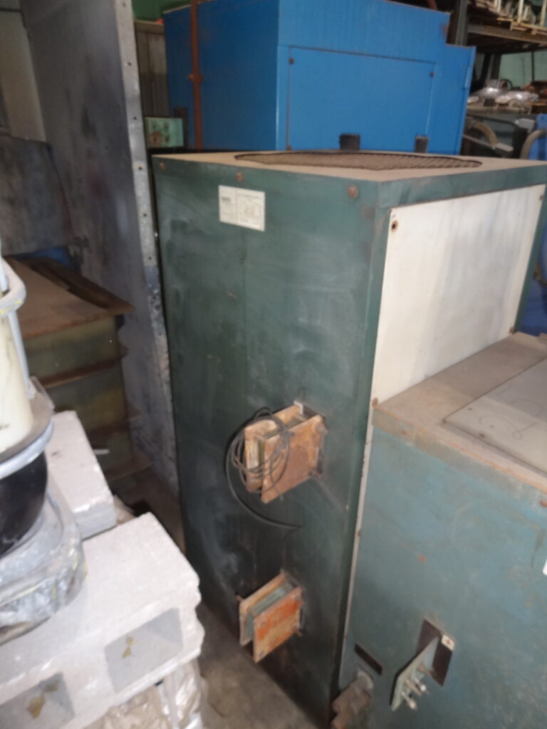 Old green industrial boiler in warehouse