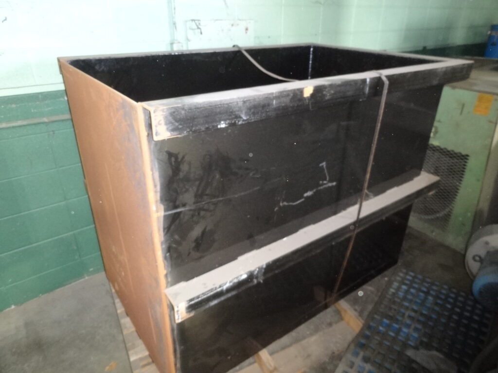 Stacked black industrial storage bins on pallet